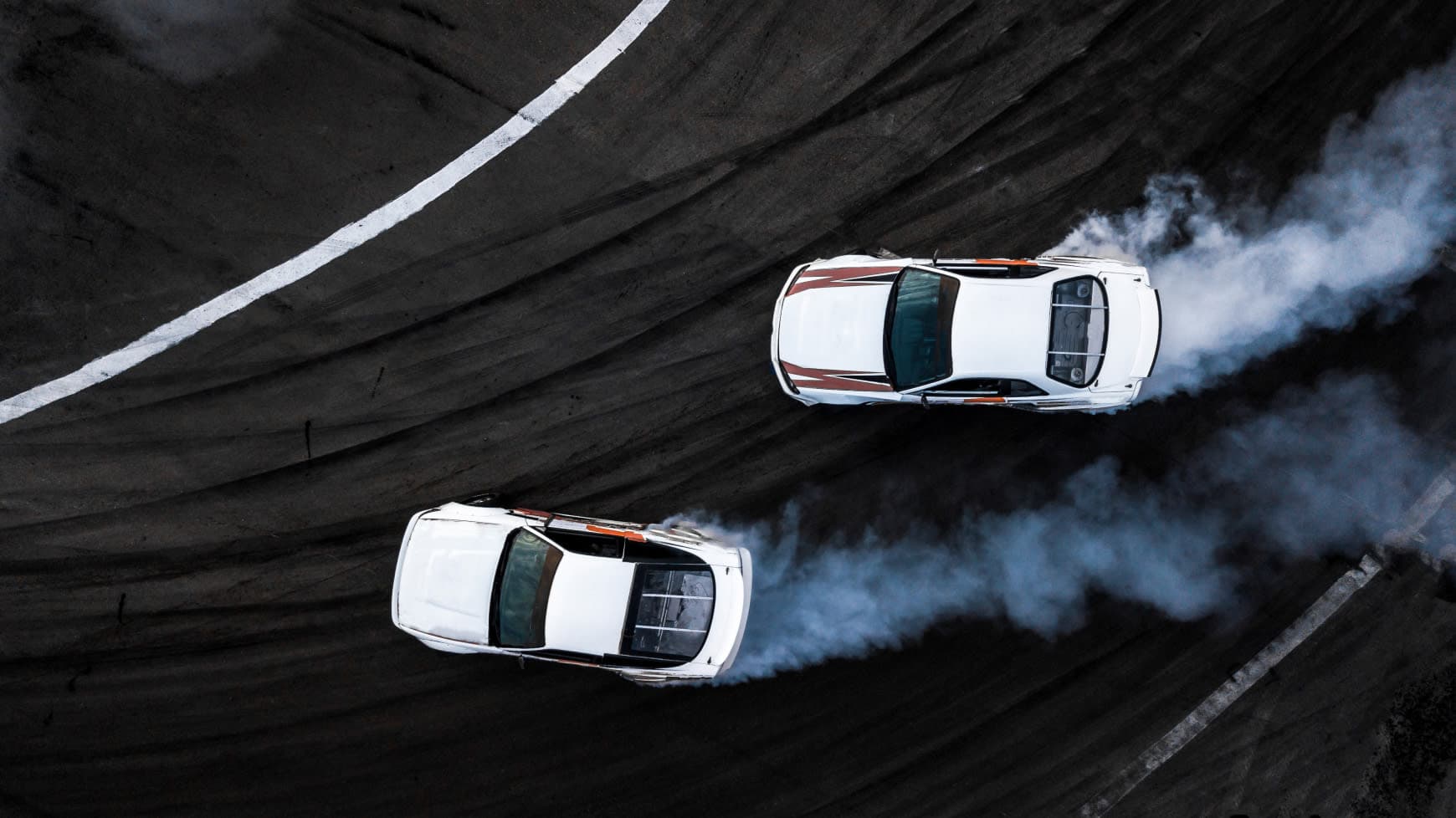 Two Racing Cars Drifting Around a Turn